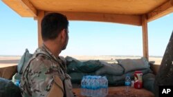 叙利亚民主力量的一名战士在叙利亚叙利亚-土耳其边境的塔尔艾卜耶德镇美军基地内站岗(2019年10月7日)。