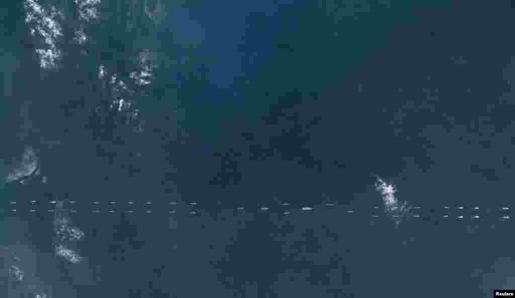 行星实验室给路透社的卫星照片显示,2018年3月26日,中国海南岛以南,军舰列队。中国的辽宁号航空母舰在南中国海进行大规模军事演习,至少有40艘军舰和潜艇分列在辽宁号航母前后,空中还有军机编队飞行。这是辽宁号服役以来第一次参与实战化演习,而且选在南中国海。