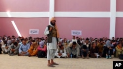 一名塔利班士兵在阿富汗加兹尼市看守一群阿富汗保安部队成员。(2021年8月13日)