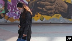 在严重污染中,有人戴口罩走在北京(2016年11月5日)