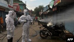 အိန္ဒိယနိုင်ငံ Siliguri မြို့မှာ တွေ့ရတဲ့ ပိုးသတ်ဆေးဖျန်းနေတဲ့ မီးသတ်တပ်ဖွဲ့ဝင်တချို့။ (ဇွန် ၂၂၊ ၂၀၂၀)