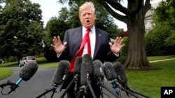 在前往纽约之前，美国总统川普在微风中在白宫南草坪对记者讲话。（2018年5月23日）