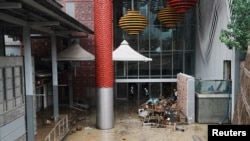 香港黃大仙港铁站及附近的商场被洪水淹没后,工人忙于进行清理善后工作 (路透社照片)