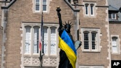 Американські ЗМІ публікують яскраві висловлювання військових, економістів та політичних оглядачів на тлі політичних суперечок у Конгресі США. На фото: прапор України довкола копії Статуї Свободи у Вашингтоні, США. AP Photo/Manuel Balce Ceneta