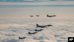 韩美日三国实施联合空中演习,旨在反制朝鲜上月31日发射“火星炮-19”型洲际弹道导弹。图为2023年12月20日,美国空军B-1B轰炸机、F-16战斗机、韩国空军F-15K战斗机和日本空军F-2战斗机再一起的联合演习中飞越韩国南部济州岛。(韩国国防部提供/美联社发布)