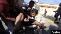 2013年11月15日,利比亚民兵在的黎波里向示威人群开枪之后,人们抢救受伤的抗议人士。