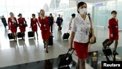 资料照：香港国泰航空公司的空姐在2003年中国非典疫情期间戴口罩上班。（2003年5月15日）