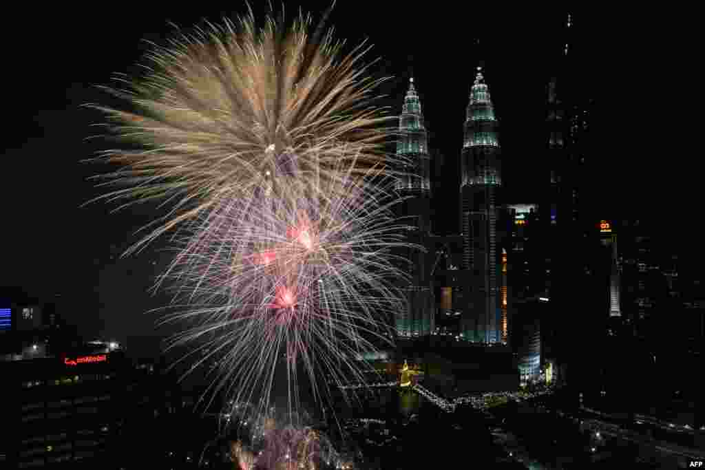 Fireworks illuminate the sky near Malaysia's Petronas Twin Towers during New Year celebrations in Kuala Lumpur, Jan. 1, 2018.