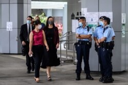 从左至右:美国、澳大利亚、新西兰的外交官们走过香港警察进入香港最高法院聆听唐英杰案的法庭审理。(2021年6月23日)