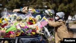 资料照片:人们献花和留言悼念在科罗拉多州博尔德大规模枪击案中被打死的警察埃里克·塔利。(2021年3月23日)