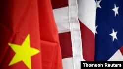 资料照片-在北京举行的中国国际服务贸易洽谈会期间,AICC的展位上的美国和中国国旗。