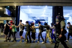 香港理工大学的抗议学生在警察的押送下离开校园。（2019年11月18日）