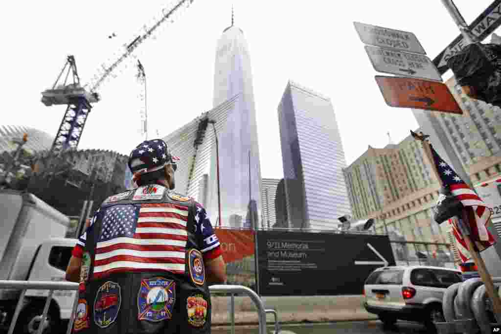 Jose Colon, of New York, looks up at 1 World Trade Center before a ceremony marking the 13th anniversary of the 9/11 attacks, Sept. 11, 2014, in New York.