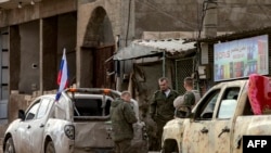 2024年12月12日,俄罗斯士兵站在军用卡车旁,准备撤离叙利亚准备撤离叙利亚东北部卡米什利(Qamishli)的阵地。