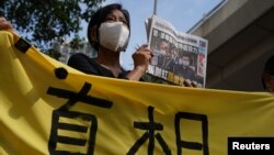 在西九龙法院的一次听证期间,一名支持者举着报纸在法院外声援《苹果日报》。(2021年6月19日)