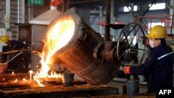 2024年12月10日,中国山东滨州一家生产内销与出口汽车零件的工厂工人在浇注钢水。