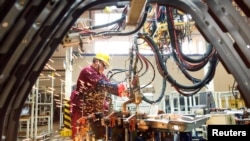 中国山东潍坊的江淮汽车制造厂的工人在生产线上(2020年2月28日)