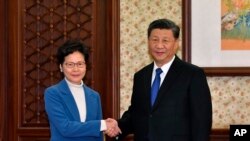 Chủ tịch TQ Tập Cận Bình bắt tay Trưởng đặc khu Hong Kong Carrie Lam ở Bắc Kinh, TQ, hôm 16/12/2019. (Hong Kong Government Information Services via AP)