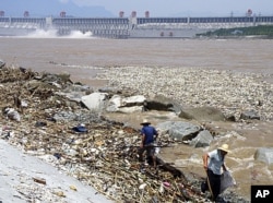 2010年8月,工人在三峡大坝附近清理洪水带来的垃圾