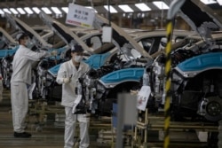 工人陪在口罩在位于湖北武汉市的东风本田汽车装配线上工作。(2020年4月8日)