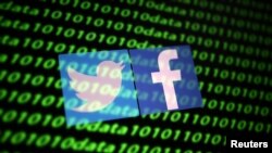 资料图片:二进制代码背景中的推特和脸书标识。(2019年11月26日)