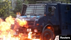 香港抗议者和警方星期天(11月17日)在理工大学外爆发激烈冲突。一辆警方车辆正在穿过大火。