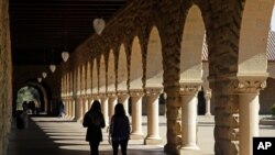 FILE - Students walk on the Stanford University campus in Santa Clara, California, March 14, 2019.
