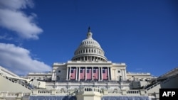 悬挂在美国国会大厦西侧的美国国旗,按照惯例,1月20日的总统就职典礼本来应该在这里举行,但因为极端严寒的天气,就职礼将抓为室内。