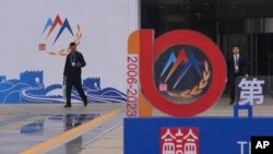 2023年10月29日(星期日),在即将在北京举行的香山论坛之前,工人们走过会场入口附近。(美联社)