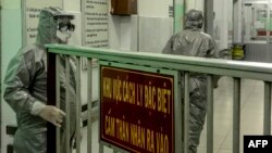 Nhân viên y tế vào khu vực cách ly để thăm hai trường hợp nhiễm coronavirus mới tại bệnh viện Chợ Rẫy, TP. HCM.