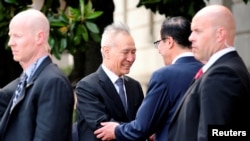 中国副总理刘鹤在美国贸易代表办公室外与美国财政部长姆努钦握手。(2019年5月9日)