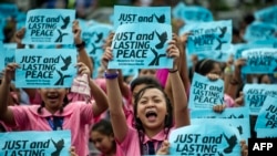 High school students hold banners calling for just and lasting peace as Philippine President Rodrigo Duterte marks his first 100 days in office in Manila, Oct. 7, 2016.