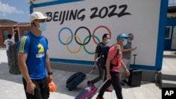 到河北省张家口崇礼的游客走过北京2022冬季奥运会的广告牌。(2020年8月13日)
