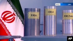 资料照片: 2018年6月6日伊朗伊斯兰共和国广播电台(IRIB,国营电视台)的画面截取自伊朗纳坦兹铀浓缩工厂的一档电视直播节目,其中展示了三台国产离心机。