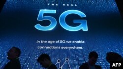 2019年电子消费展在拉斯维加斯会展中心举行,与会者在高通展台前排队等待5G展示。