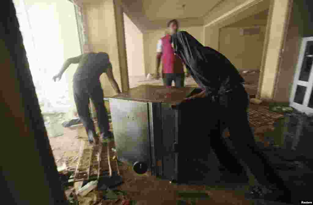 2013年7月1日,抗议者焚烧了穆斯林兄弟会在开罗穆卡塔姆区的总部后,趁火打劫者把一台炉灶拖走。