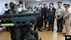 资料照:台湾总统赖清德(前排右三)在台湾北部桃园巡视军队时观看“毒刺”导弹发射器展示。(2024年5月23日)