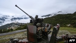 资料照:中印边界争议地区实际控制线(LAC)附近的一名印度士兵在L70高射炮炮位上。(2021年10月20日)