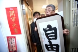 资料照:台湾台北铜锣湾书店创办人林荣基手持台湾公民参与协会理事长何宗勋写的“自由”字画。