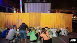 在黄色栏板被拆除前,郑州市民前往地铁5号线沙口路站口献花悼念水灾死难者。(2021年7月26日)