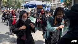 塔利班政府对阿富汗妇女施加了一系列限制;图为利班武装人员在喀布尔向空中开枪驱散阿富汗妇女抗议者。(法新社:2022年8月13日)