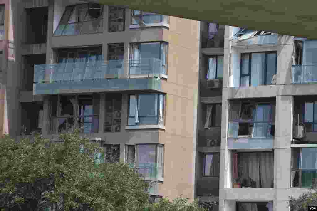 天津爆炸事故现场,核心爆炸区周围多座居民楼窗户被震碎,高速公路桥梁受损,多辆大货车被炸翻,小汽车起火或被砸,多名当地居民仍逗留在事故现场。(美国之音记者东方拍摄)