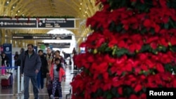 2022年12月20日,乘客在华盛顿里根国家机场走过。全国大部分地区的冬季风暴可能会导致圣诞节假期的旅行延误。(路透社照片)