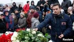 2015年2月28日,反对派活动人士伊利亚·亚辛(Ilya Yashin)在涅姆佐夫遇刺地点献花悼念。
