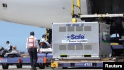 台湾工人在桃园国际机场从日本飞机上卸下日本捐赠的新冠病毒疫苗。(2021年7月8日)