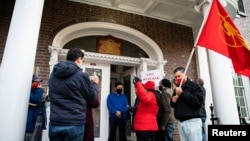 资料照片:抗议者在缅甸驻华盛顿大使馆外示威,反对军人政变并要释放昂山素季。抗议期间,人们与一位听到敲门声后开门的男士说话。(2021年2月9日)