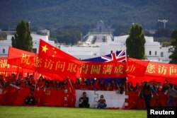 亲中国的支持者在澳大利亚堪培拉议会大厦前举旗帜欢迎中国总理李克强到访澳大利亚。(2017年3月23日)