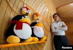 2011年6月9日,腾讯董事长兼首席执行官马化腾在深圳南山高科技工业园区的公司总部内接受路透社采访,旁边是腾讯网的吉祥物。