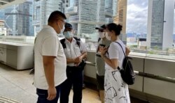 有警长在高等法院门外,与要求重判唐英杰的亲中人士商讨示威安排 (美国之音/汤惠芸)