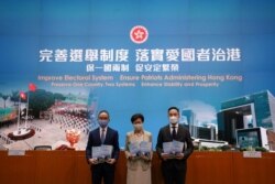 香港特首林郑月娥(中)在香港举行的相关中国人大通过香港选举新规的记者会上。(2021年3月30日)